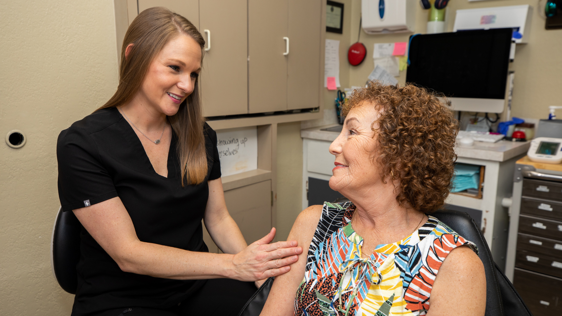 a dental professional speaking gently with a smiling patient