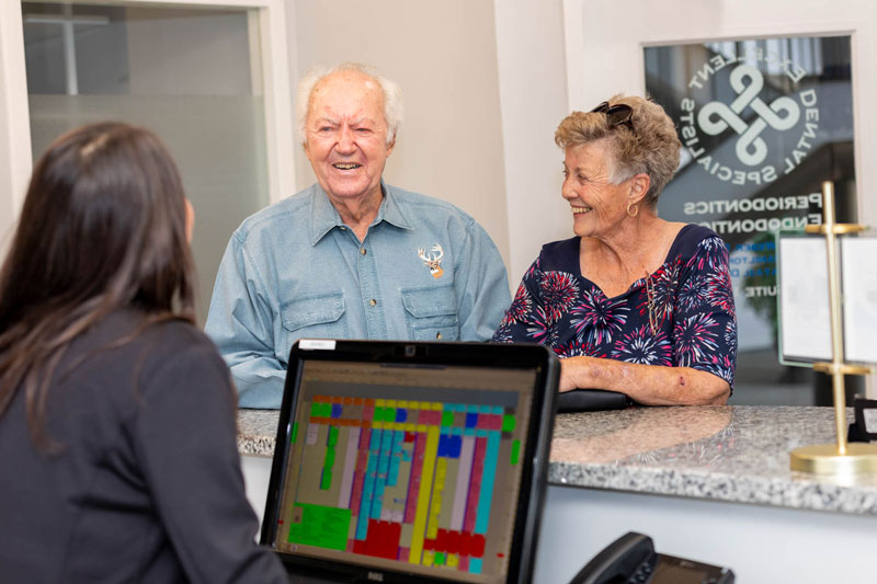 a treatment coodinator helping a dental implant patient at excellent dental specialists